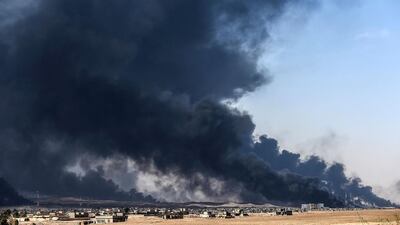 Smoke rises from burning oil wells on October 18, 2016, near the town of Qayyarah, south of Mosul, during the operation to recapture the city from the Islamic State group. Bulent Kilic / Agence France-Presse