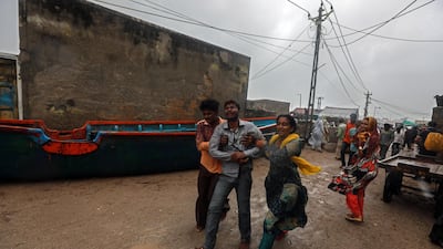 People takes a fisherman to hospital during rain as he got injured while moving a fishing boat to a safer place along the Arabian sea coast, as the Cyclone Vayu approaches Veraval, India. EPA