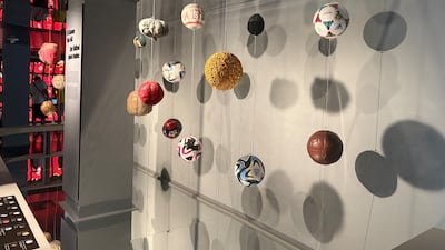 Footballs hang from a cielling as part of an exhibit in Miami. Kyle Fitzgerald / The National