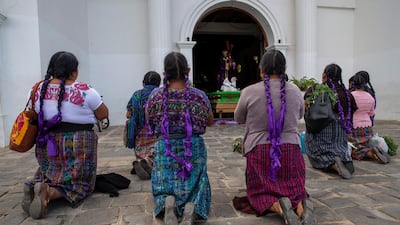 Kaqchikel indigenous women pray toward a statue of Jesus outside a Catholic church in San Martin Jilotepeque, Guatemala. The statue was placed outside the door of the church, which remains closed as part of emergency measures to help stop the spread of the new coronavirus. AP Photo