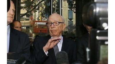 Rupert Murdoch, centre, attempts to speak to the media after he held a meeting with the parents and sister of murdered school girl Milly Dowler in London on Friday. The lawyer for Milly Dowler's family says Rupert Murdoch has issued a full and sincere apology to the murdered schoolgirl's family for the actions of journalists at his newspaper. Kirsty Wigglesworth / AP Photo