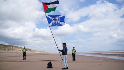 A protester on Balmedie Beach holds a Palestinian flag and a pro-Scottish independence flag. AP