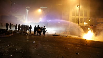 Lebanese riot police use a water cannon to extinguish a fire that was set by protesters in Beirut. AP Photo