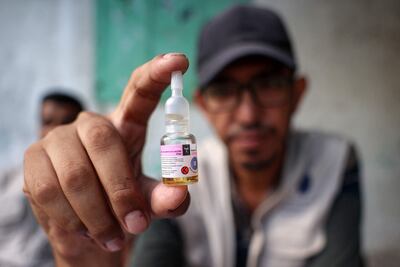 A health worker holds a vial of polio vaccine being administered to children in Deir Al Balah in the central Gaza Strip. AFP