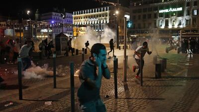 People run after police fired tear gas following clashes after the Euro 2016 soccer championship group B match between England and Russia in Marseille, France. Clashes between football fans Saturday in Marseille’s Old Port occurred for a third straight day of violence in the city. Darko Bandic / AP