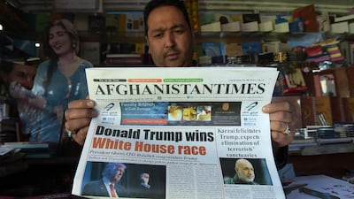 An Afghan man reads a newspaper displaying an image of victorious Republican candidate Donald Trump and coverage of the US presidential elections, in Kabul. Shah Marai / AFP