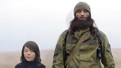 An image grab taken from a video reportedly taken on November 24, 2014 allegedly shows an ISIL fighter speaking to the camera next to a child, who is identified in an earlier propaganda video as Abdullah from Kazakhstan, before the child executes two men. Al Hayat Media Centre/AFP Photo/Handout