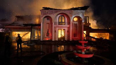 Firefighters work to put out a structure burning during a wildfire Wednesday, May 11, 2022, in Laguna Niguel, Calif. (AP Photo/Marcio J. Sanchez)