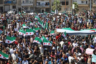 Protesters wave the Syrian flag as they demonstrate in the rebel-held city of Idlib on September 7, 2018. AFP