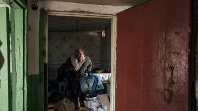 A local resident carries her belongings as she leaves her home in Bakhmut, Donetsk region, Ukraine. AP