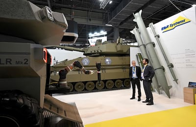 Israeli defence firm Elbit Systems staff stands on the booth at a French arms fair. Emmanuel DUNAND / AFP