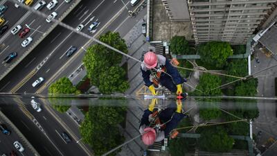 A worker cleans windows on a building in Shanghai. AFP