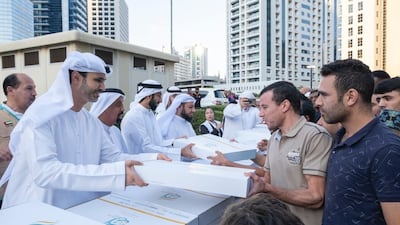 Officials distribute iftar meals in Barsha Heights to mark the start of Ramadan. Photo: Iacad