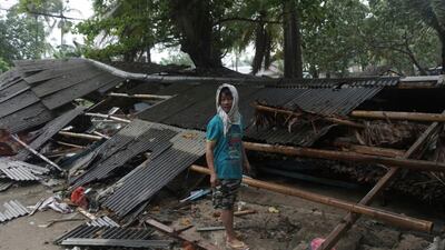 A man inspects his house which was damaged by a tsunami, in Carita, Indonesia. AP