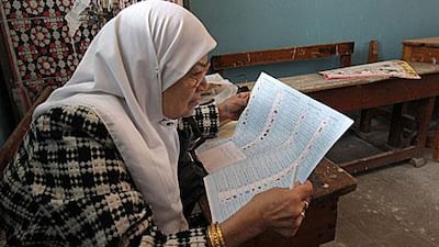 An Egyptian woman studies her ballot paper in a polling station in Cairo on Sunday during the first round of the Shura Council elections.
