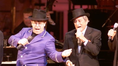 Elton John, in a lilac suit, with Tony Bennett on stage at the Rainforest Foundation Benefit at Carnegie Hall in New York City on April 17, 1999. ImageDirect