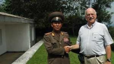 Walter Keats poses with a military official in North Korea, a country he visited twice in August alone.