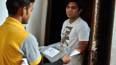 A resident receives a delivery from a Gojavas parcel agency staff, which handles Jabong products in Ghaziabad, India. Pradeep Gaur / Mint via Getty Images