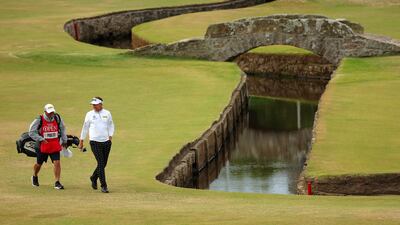 Ian Poulter of England walks with his caddie on the first hole. Poulter, who was booed on the first tee, shot 69 to end the day at three under par. Getty