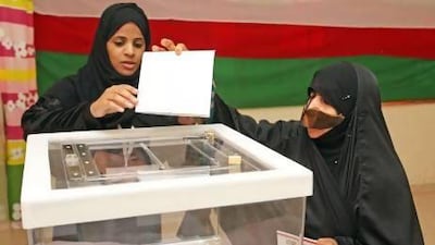 An Omani woman casts her vote at a polling station yesterday in Oman's first municipal election.