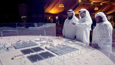 Officials and delegates from Dewa look at a model that represents the entire proposed Mohammed bin Rashid Al Maktoum Solar Park. Antonie Robertson / The National