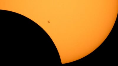 The International Space Station is silhouetted against the sun during a partial solar eclipse as seen from Ross Lake, Northern Cascades National Park, in Washington. Bill Ingalls / NASA via AP