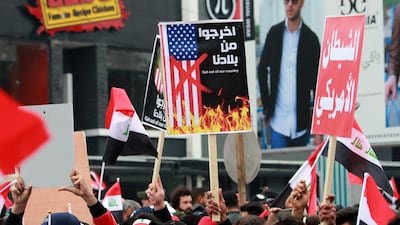 A supporter of Moqtada Al Sadr carries a banner reading in Arabic 'Get out of our country' during a demonstration. AFP