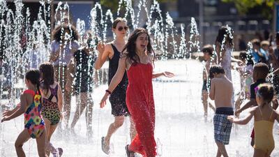 People enjoy the water fountains in King's Cross, London. EPA