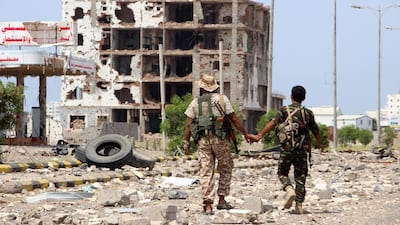 Houthi rebels pass a destroyed building in Hodeidah during the deployment of observers on front lines in the Yemeni port city on October 19, 2019. EPA