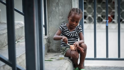 A child pretends to feed the head of a broken doll at Argentine Bellegarde National School