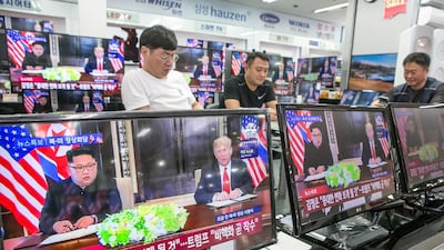 Television screens, displaying a news broadcast of U.S. President Donald Trump and North Korean leader Kim Jong Un attending a document-signing event in Singapore, stand in an electronics store in Seoul, South Korea. Jean Chung / Bloomberg