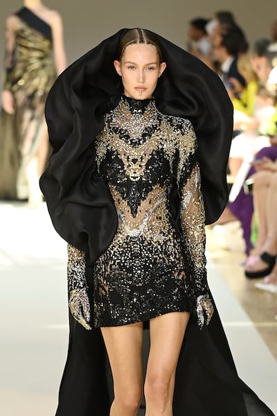 The Elie Saab haute couture autumn/winter 2022-23 show delivered a new softness over Saab's trademark handwork, seen here as a cowled hood, over a decorated mini dress. Getty Images