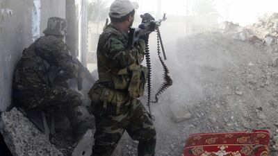 Iraqi Shiite Hezbollah Brigade militiamen fire weapons against ISIS militants in Husaybah, east of Ramadi.