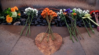 Flowers are placed at a memorial during a healing garden dedication. EPA