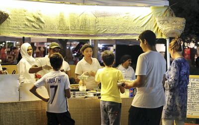 People buying food from House of Sweets café at the Ripe Market held at Al Barsha Pond Park in Dubai. Pawan Singh / The National