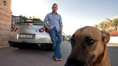 Scott Wilcox with Hazel, one of his two dogs, and his Nissan GT-R. Wilcox is giving his old car, a 2002 Maserati 3200, to a friend as a wedding gift.