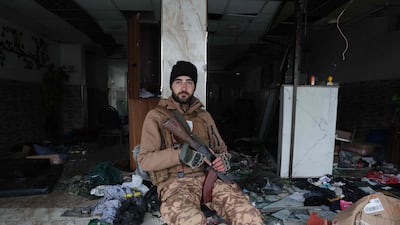 A Syrian security officer sits amongst strewn items and broken glass following a ceasefire which ended several days of fighting between. AFP