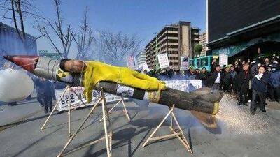 South Korean activists stage a mock launch of a North Korean missile carrying an effigy of Kim Jong-Un, the new North Korean leader, at a rally denouncing the North's announcement of a planned satellite launch. Seoul says the North is nuclear testing.