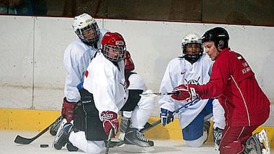 Coach Matti Fagerstrom, in red outfit, works with his players.