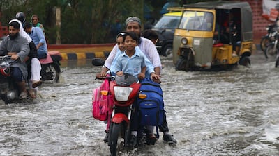 People make their way through a flooded area after heavy monsoon rains in Karachi, Pakistan in August 2022. EPA