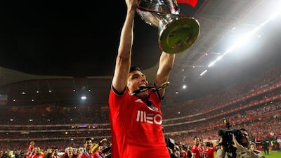 Benfica's Oscar Cardozo, from Paraguay, lifts the trophy celebrating after beating Olhanense on Sunday at Estadio da Luz. Benfica's 2-0 clinched them the Portuguese Primeira Liga championship. They will play Juventus in the the first leg of their Europa League semi-final tie on Thursday April 24. Francisco Seco / AP / April 20, 2014