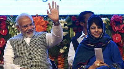 Indian Prime Minister Narinder Modi waves as he sits next to Jammu and Kashmir Chief Minister Mehbooba Mufti during the inauguration if the 330mw Kishenganga hydroelectric project in Srinagar on May 19, 2018. Tauseef Mustafa / AFP