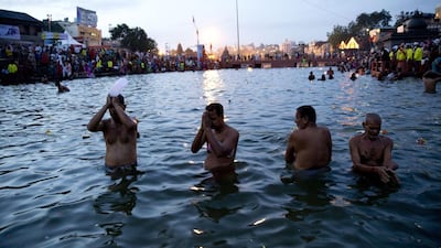 Indian devotees perform rituals as they take holy dips in the Godavari River during Kumbh Mela, or Pitcher Festival, in Nasik, India. Tsering Topgyal / AP Photo