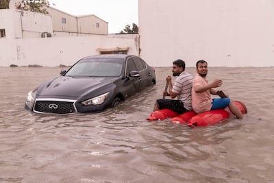 Two men fashion a raft from gas cylinders during the floods in Dubai in April. Antonie Robertson / The National