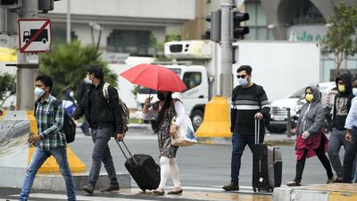 Umbrellas come out as rain begins to fall in Abu Dhabi. Khushnum Bhandari for The National