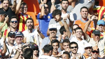 Valencia midfielder Pablo Piatti, centre, celebrates with his teammates Andre Gomes, left, and Rodrigo Moreno, right, after scoring the opening goal in their La Liga victory over Espanyol on Sunday. Kai Foersterling / EPA / September 14, 2014