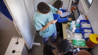 A nurse prepares a dose of the Pfizer-BioNTech Covid-19 vaccine for administration to a foreign national at a vaccination centre in Tel Aviv. Bloomberg