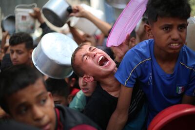 Palestinians wait for food at a distribution point in Nuseirat, in the central Gaza Strip, on Wednesday. AFP