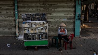 A vendor selling used remote controls for home appliances at Nhat Tao market, the largest informal recycling market in Ho Chi Minh City, Vietnam. AP