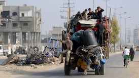 Palestinians move what is left of their belongings along a road near the Nuseirat refugee camp in central Gaza on Sunday. AFP